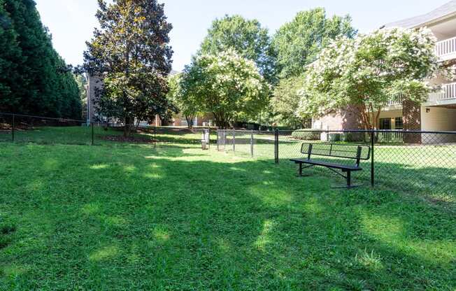 a park with a bench and a chain link fence