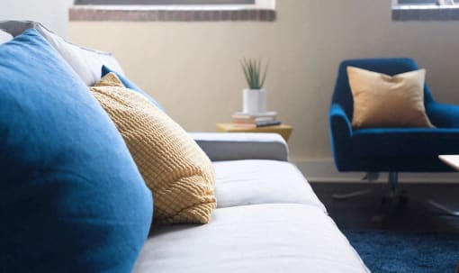 a couch with pillows and a chair in a living room