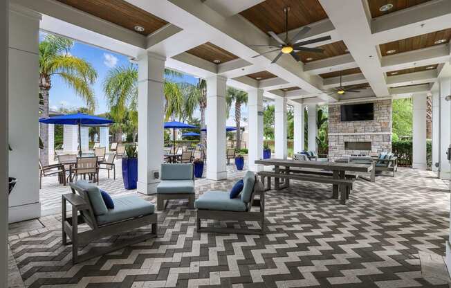 a patio with a fireplace and chairs and tables