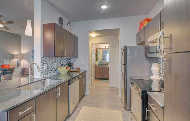 A kitchen with a refrigerator, sink, and cabinets.