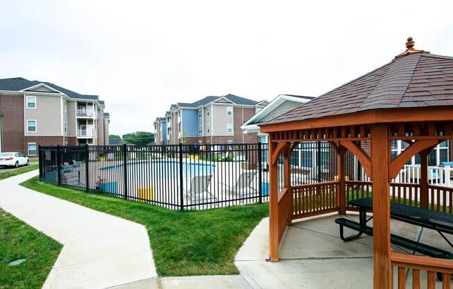 Gazebo in front of a pool with apartment buildings in the background at Mosaic Apartments in Avon, Indiana