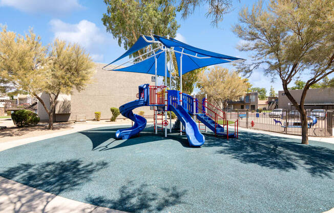 a playground with a blue and red slide at the villas at falling waters townhomes