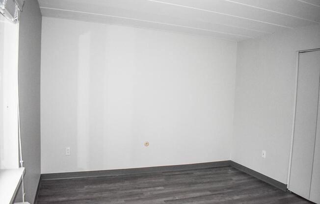 A room with a wooden floor and white walls.