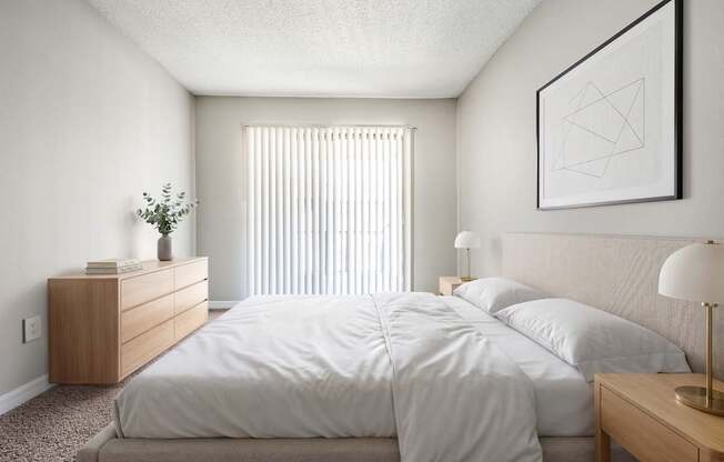 A bedroom with a large bed and a nightstand with a lamp.
