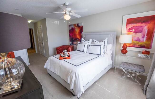 A bedroom with a large bed and a ceiling fan.