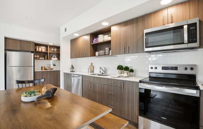 a kitchen with stainless steel appliances and a wooden table