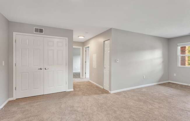 the living room and bedroom of an empty home with white doors