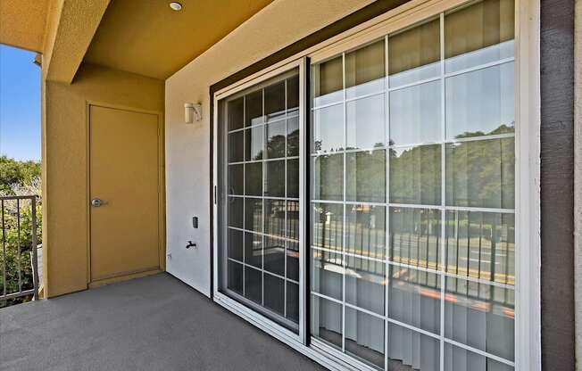 A yellow door is on the left of a glass window.