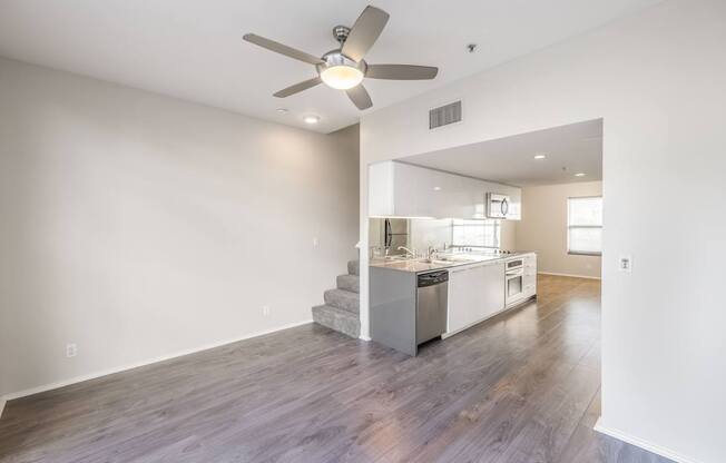 A modern kitchen with a staircase leading to the upper level.