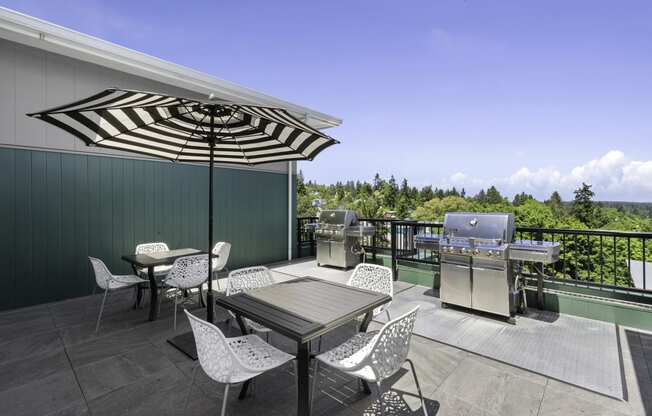 a patio with a table and chairs and a grill  at Sedona Apartments, Seattle, 98115