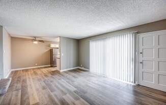 A room with wooden flooring and a white door.