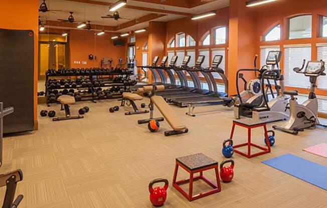 a spacious fitness center with treadmills and other exercise equipment