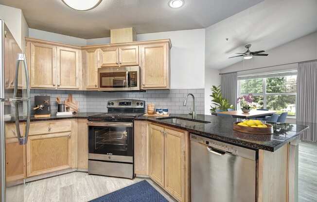 a kitchen with wooden cabinets and a black counter top