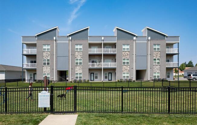 an apartment building with a black fence in front of it