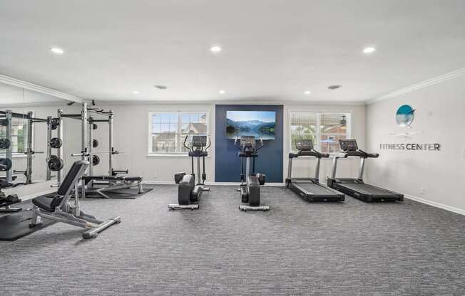 A well-equipped gym with a variety of exercise machines and weights.