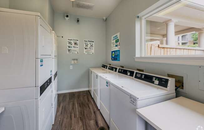 a laundry room with two washes and two sinks and a refrigerator