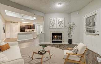 A living room with a fireplace and two chairs.