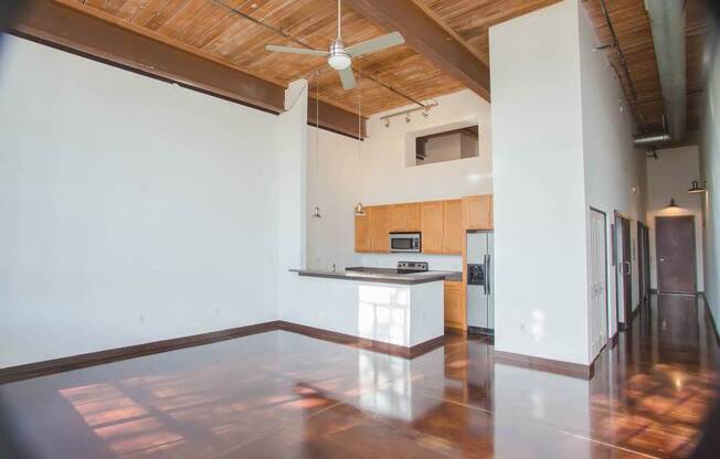 A kitchen with wooden floors and a ceiling fan.