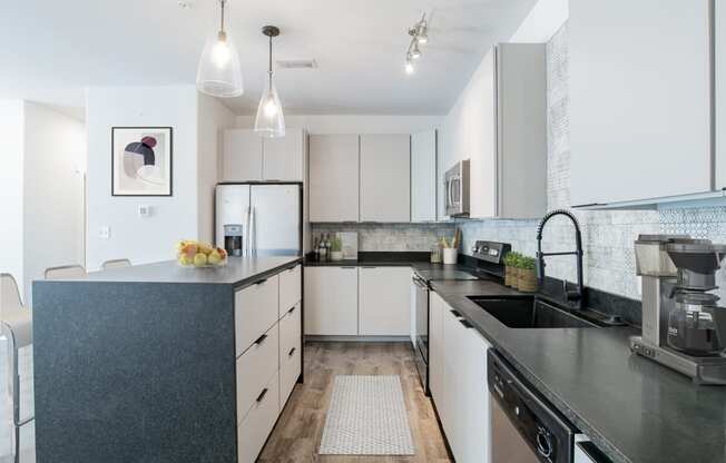 a modern kitchen with black counter tops and white cabinets