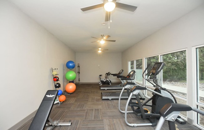 Apartments For Rent In Vestavia Hills, AL - MarQ Vestavia - Fitness Center With Exercise Balls, Large Windows, Ceiling Fans, Workout Bench, Treadmills, And Elliptical Machine