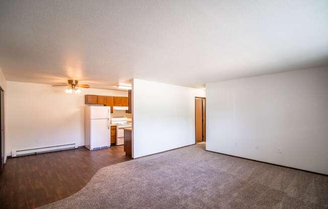 Bismarck, ND Rosser Apartments. an empty living room with a kitchen in the background