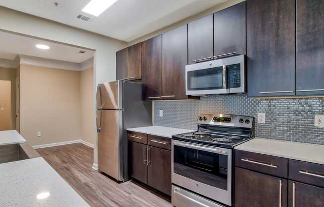 a kitchen with dark wood cabinets and stainless steel appliances