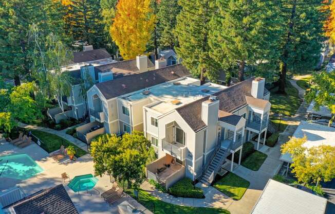 Drone image of the property and the neighborhood taken right above the community.  Many tress and apartment exterior buildings