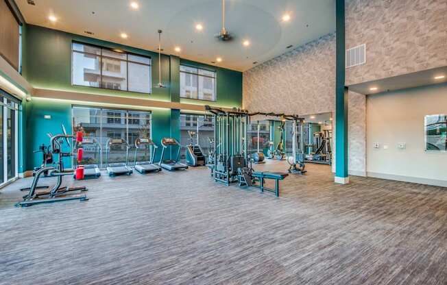 A gym with a variety of equipment including treadmills, weights, and exercise machines.