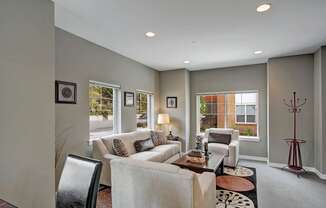 A living room with a couch, chairs, and a coffee table.