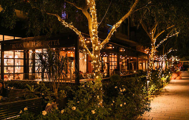 A restaurant named Buona Ferretti is lit up at night with lights and decorations.