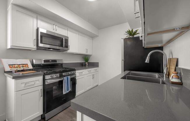 A kitchen with a black countertop and white cabinets.