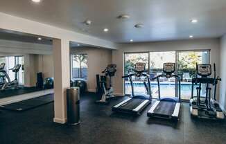 Brand New Fitness Center including treadmill, stationary bike, yoga with a pool view