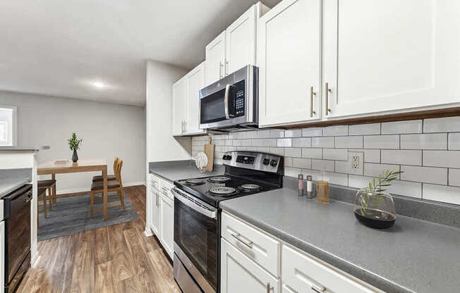 Model Kitchen with White Cabinets and Wood-Style Flooring at Lake Cameron Apartments located in Apex, NC.