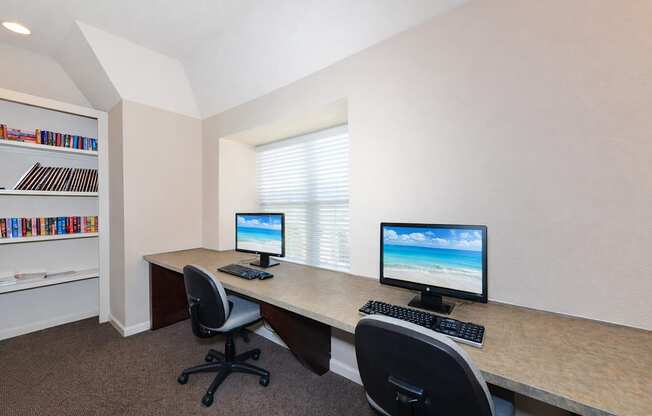 A room with a desk, two chairs, and a bookshelf.