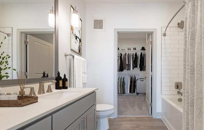 a bathroom with a sink and a toilet and a walk in closet