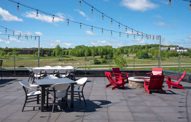 A patio with a table and chairs and string lights.