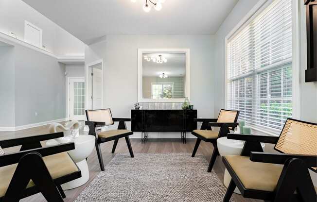 a living room with white walls and a black table and chairs