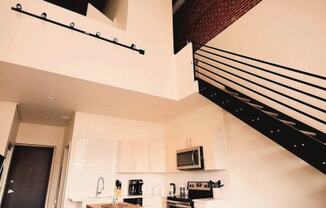 a white kitchen with a microwave and a sink