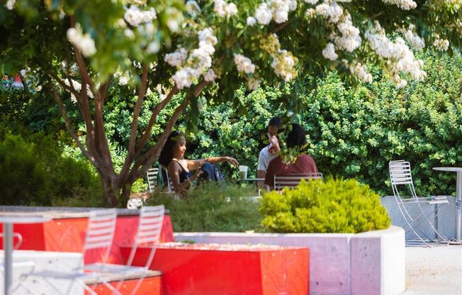 a group of people sitting at a table in a park