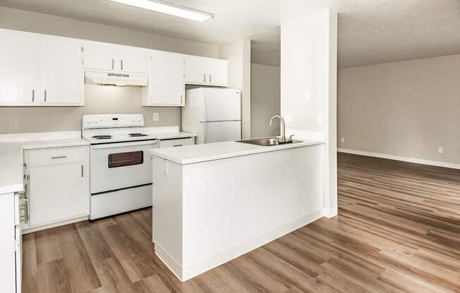 A kitchen with white appliances and wooden floors.
