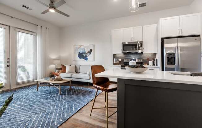 an open living room and kitchen with a refrigerator and a microwave