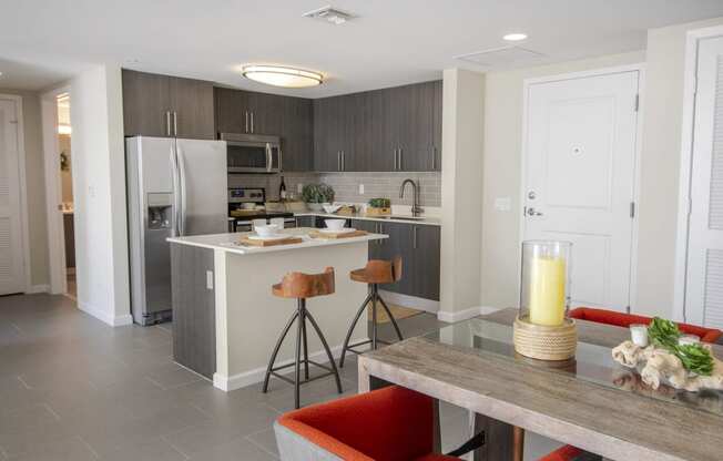 a kitchen and dining room with a table and chairs and a refrigerator