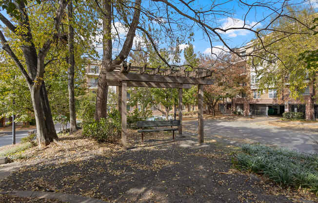 A metal bench underneath a pergola at Ten05 West Trade Apartments.