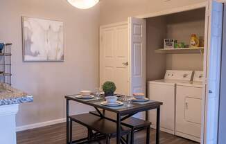 an open kitchen and dining area with a table and chairs and a refrigerator