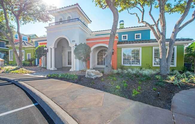 A white building with a green roof is surrounded by trees and plants at Reserve at Canyon Creek,San Antonio,TX,78230