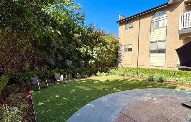 A backyard with a green lawn and a concrete patio.