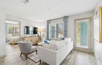 A living room with a grey couch, a chair, and a television.