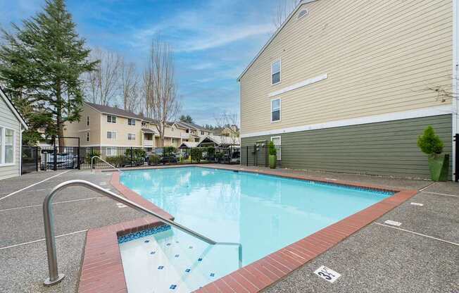 A small pool with a red border and a metal handrail.