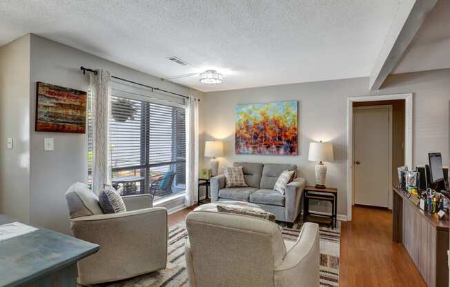 a living room with couches and chairs and a large window