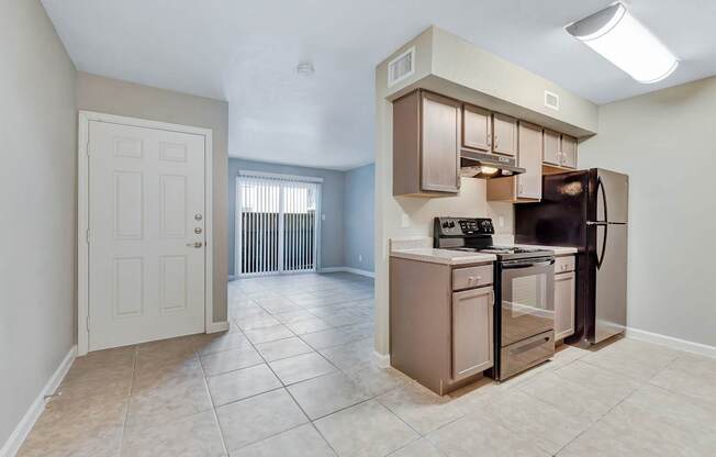 A kitchen with a refrigerator, oven, and microwave.